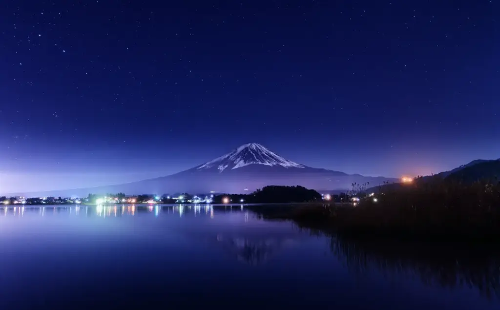 Mt. Fuji at night with starry sky and lake reflection